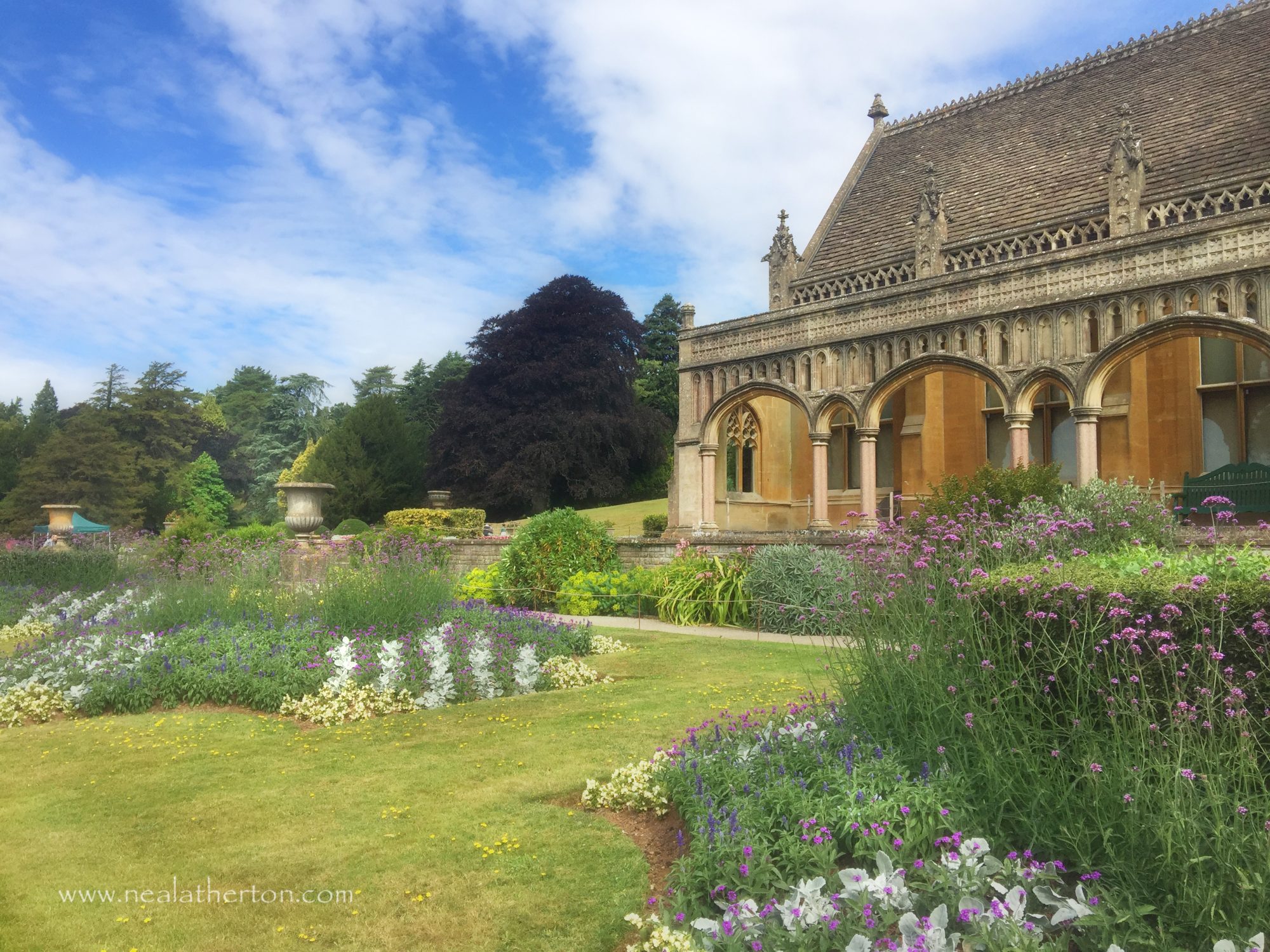 Alt="Tyntesfield house with flower beds in front of the patio"