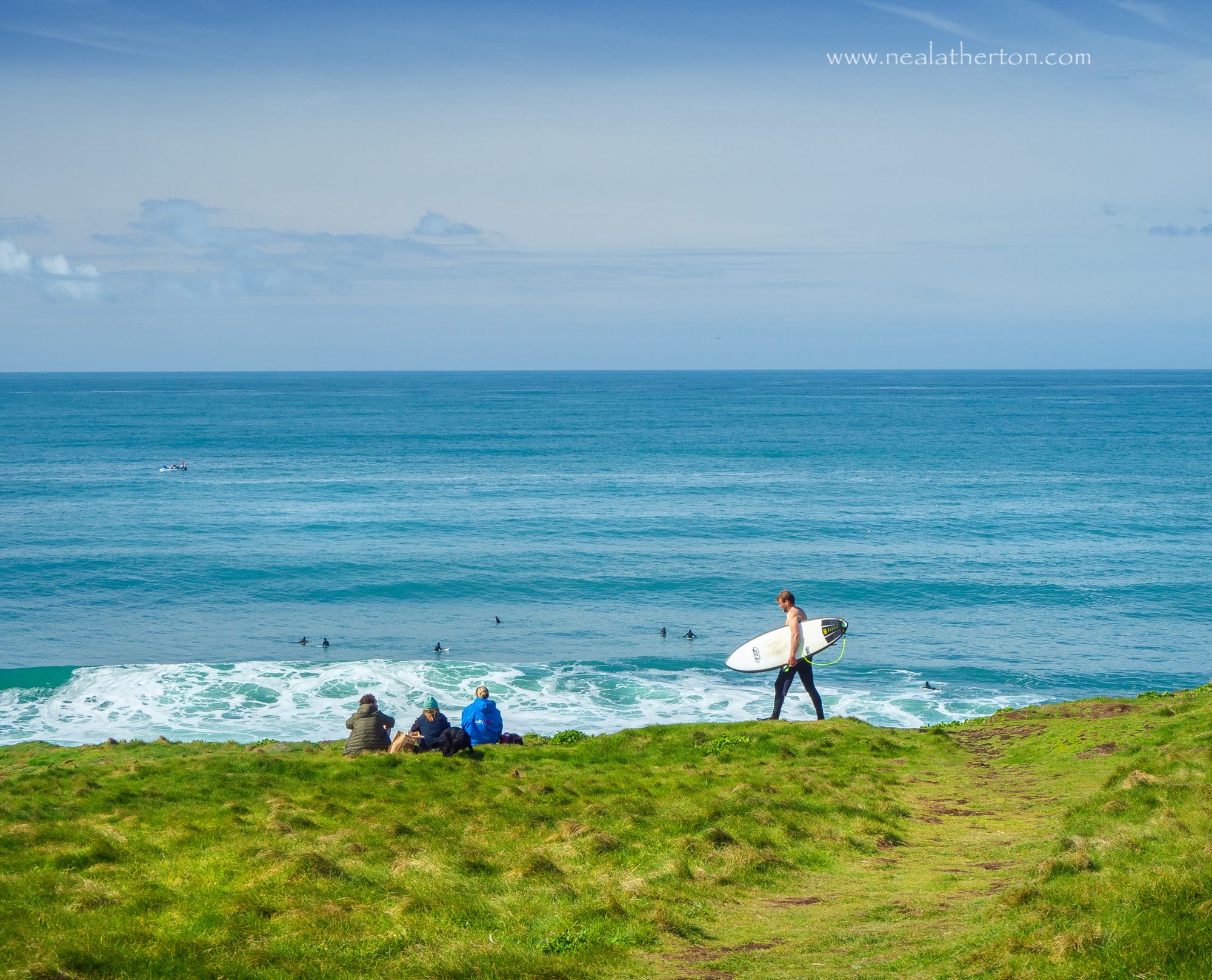Lively waves above Porthleven draw many surfers out into the sea