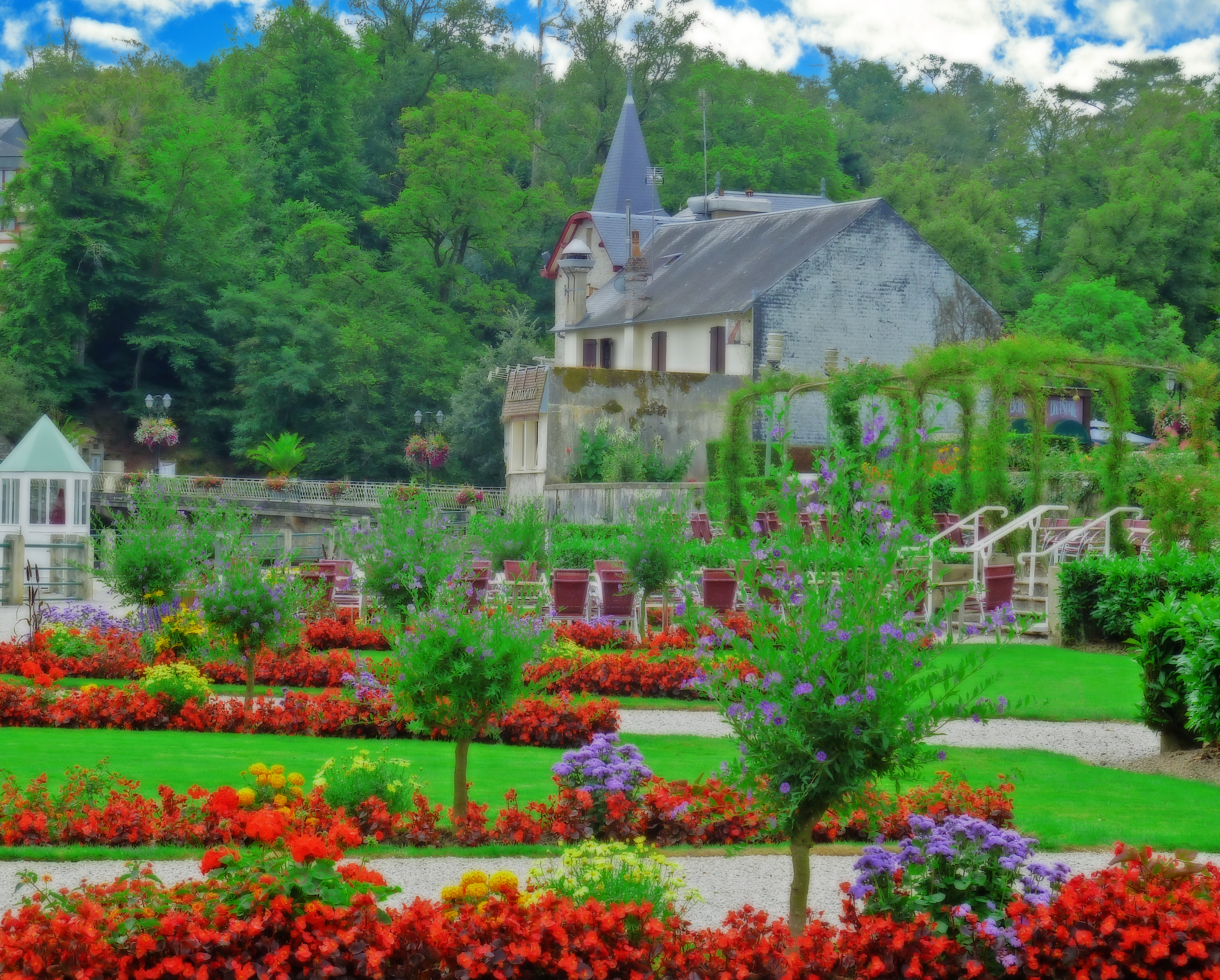 Colourful flower display and lawns with picturesque buildings in Normandy spa town