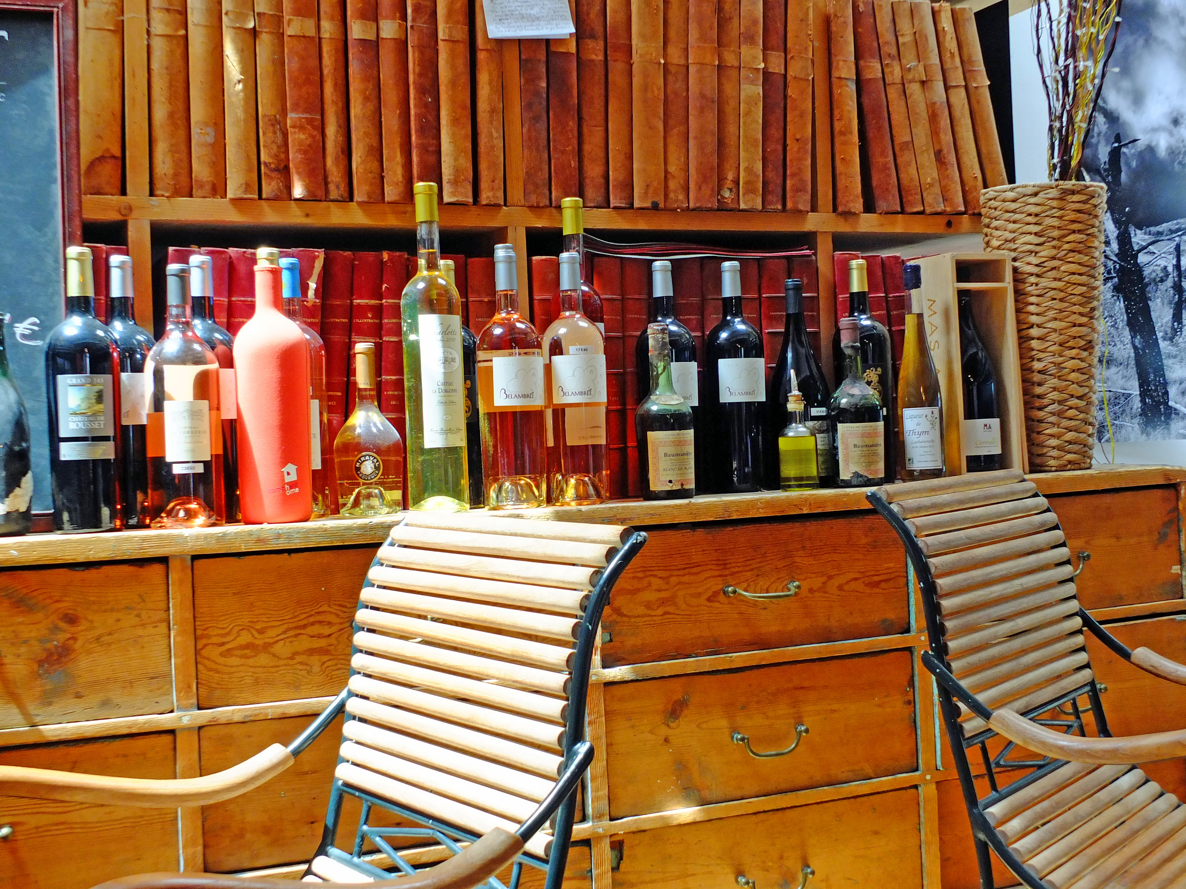 Full wine bottles and chairs with cabinet in wine bar provence france