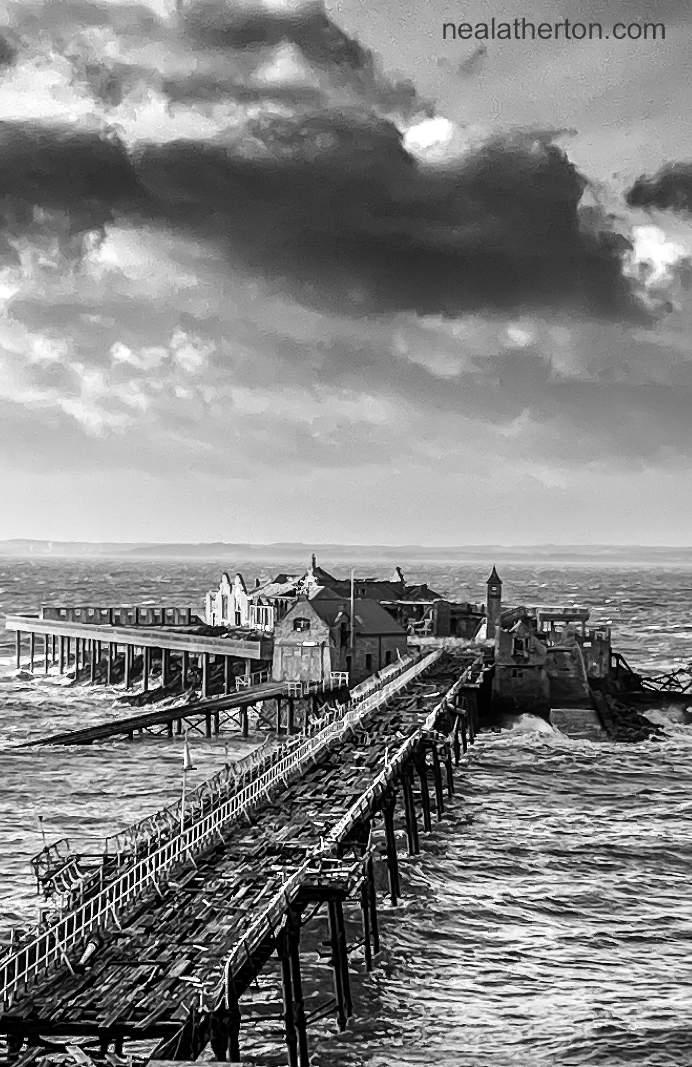 Crashing waves hit a pier with wales in the distance with stormy clouds above