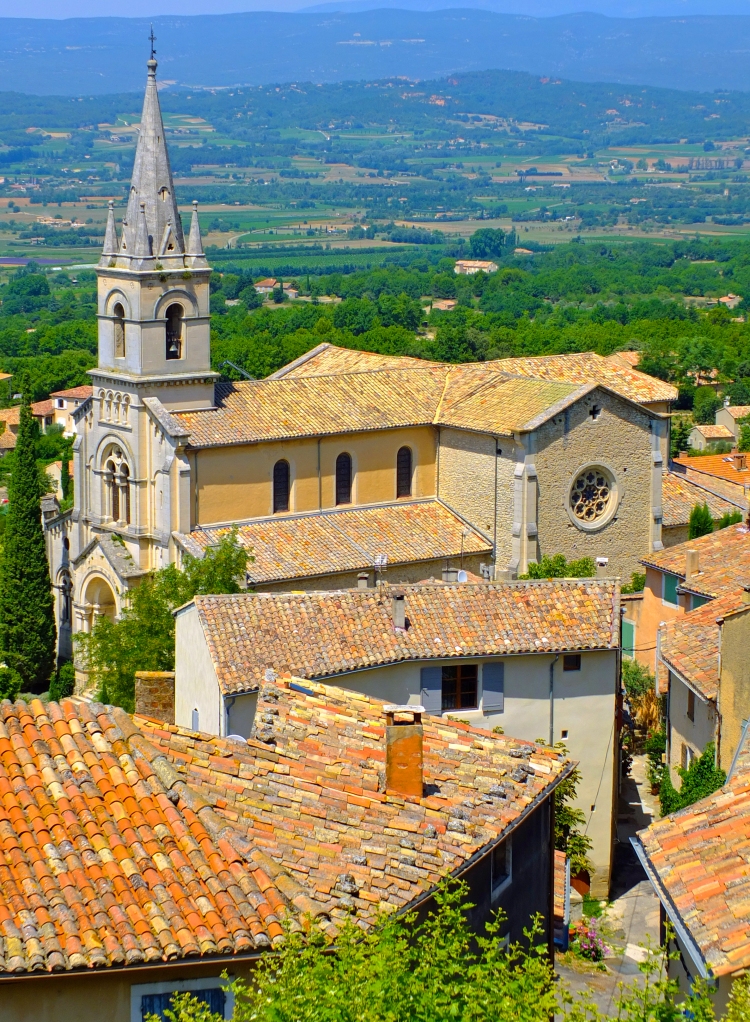 church amongst tiles roof building in Bonnieux Provence France with luberon hills