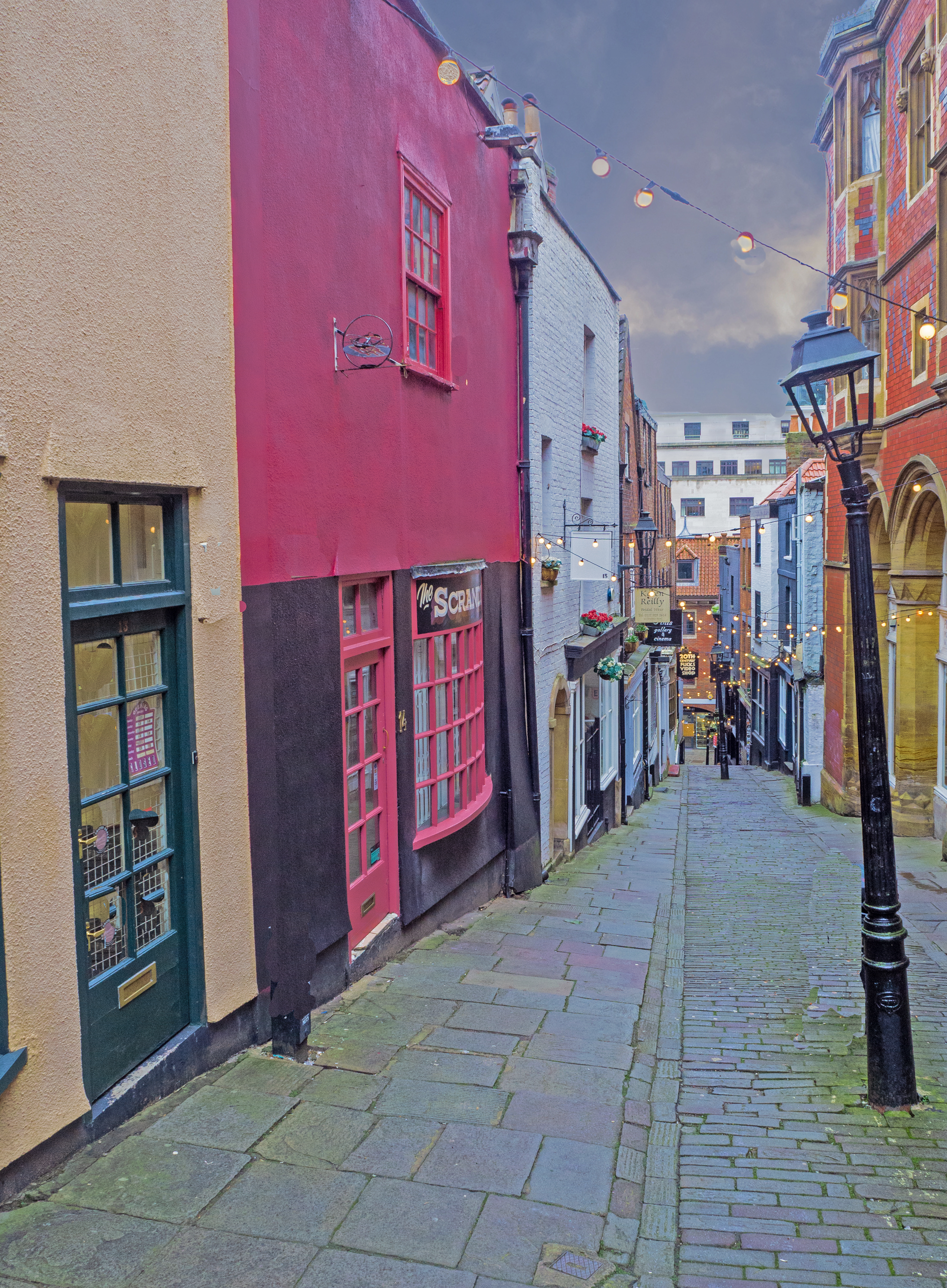 lampost and cobbles on sloping street with old buildings in bristol uk