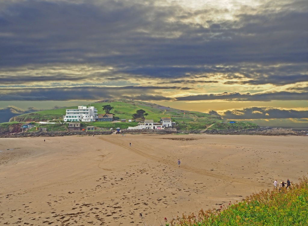 sandy beach with island and hotel and unsettled sky