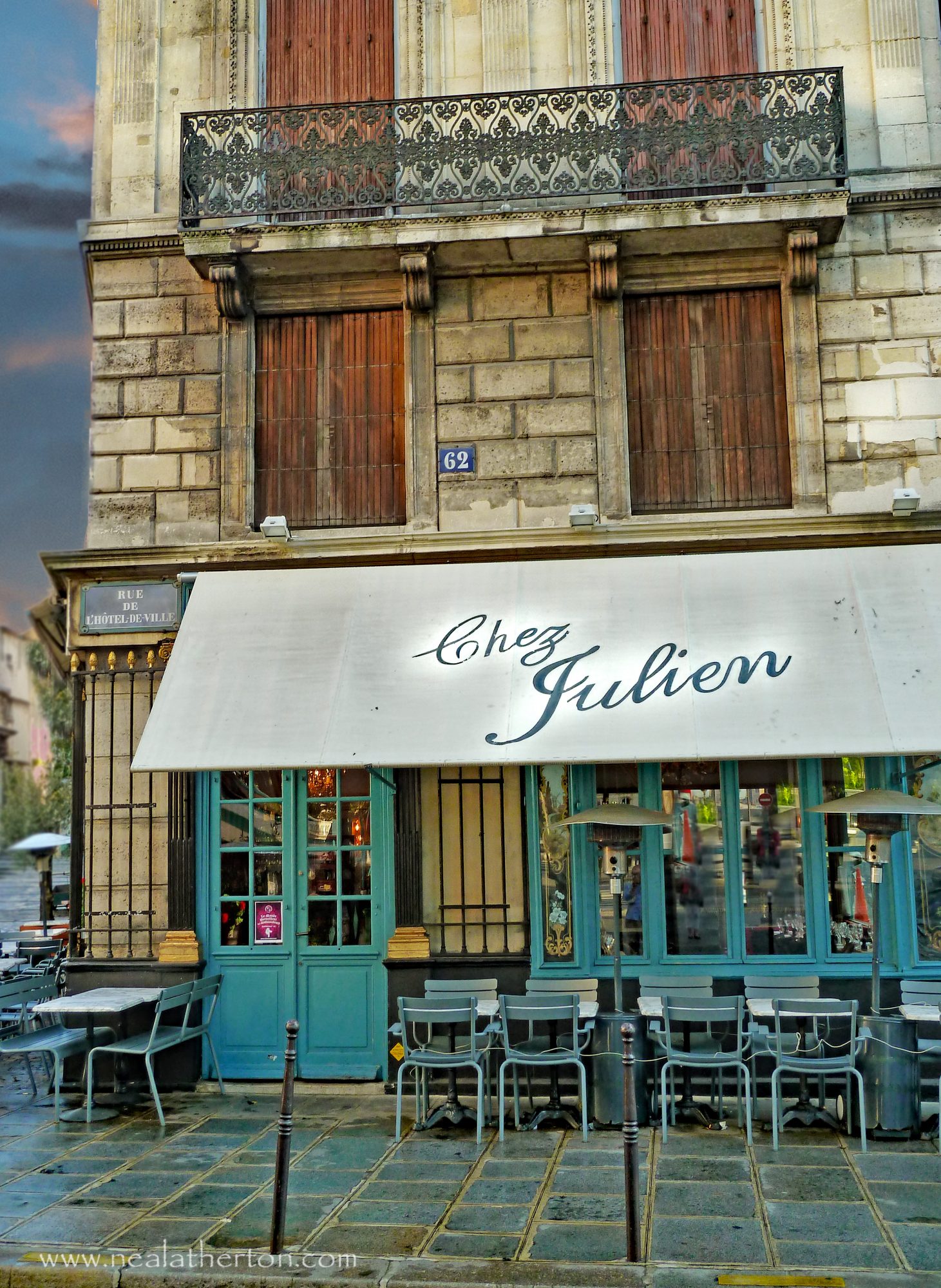 chairs in front of restaurant with street sign and paved terrace