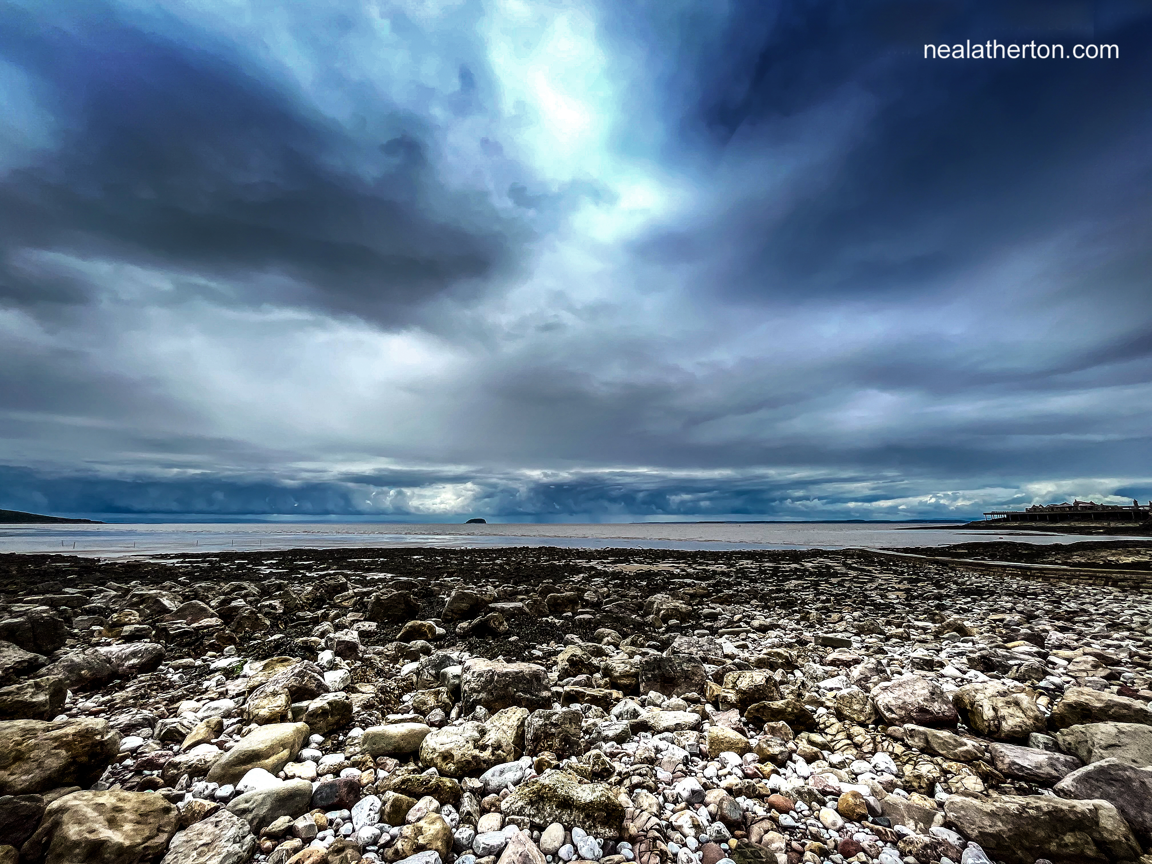 Threating skt over sea and cove with pebble shore and island