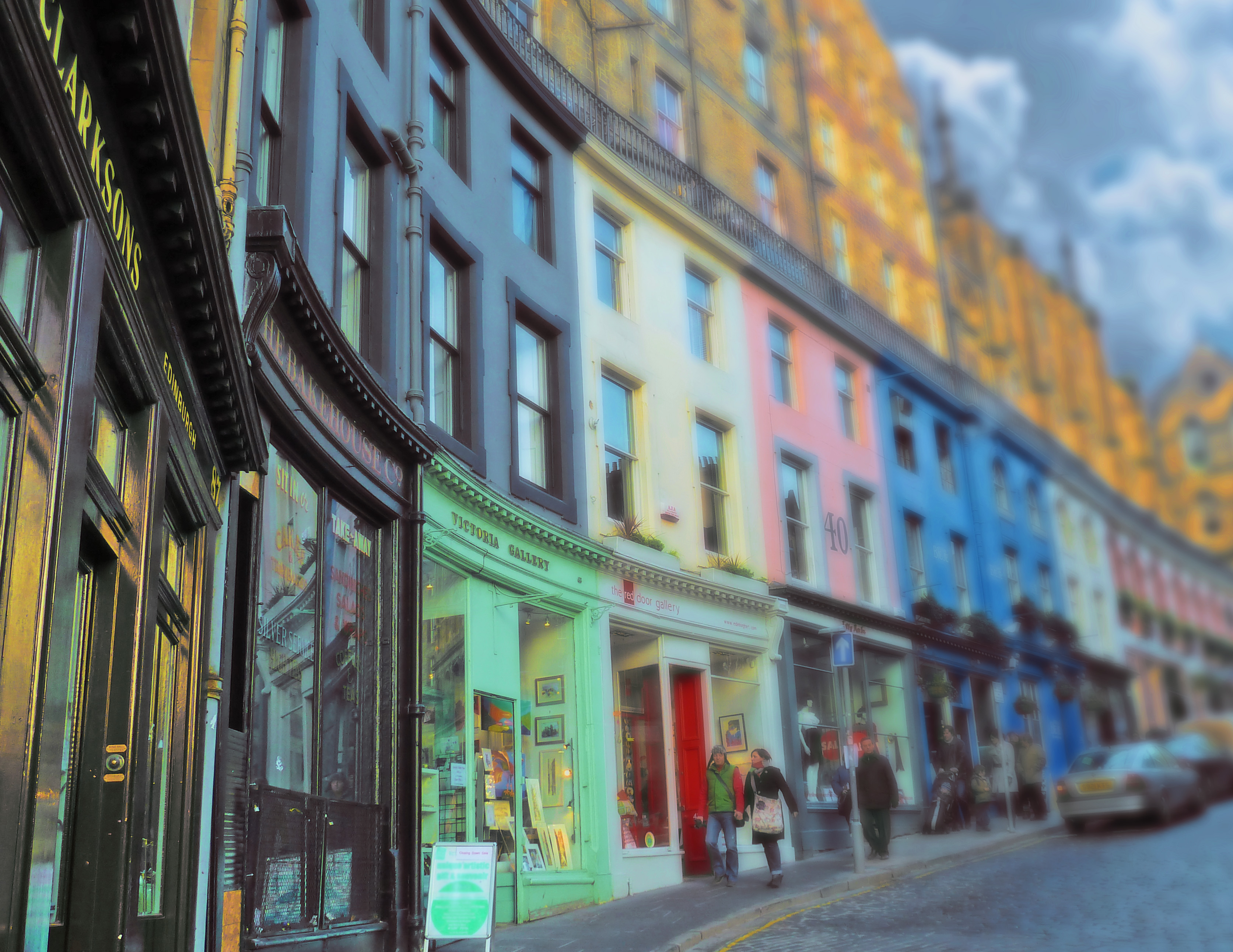 people on street with old shops and high buildings in scotland