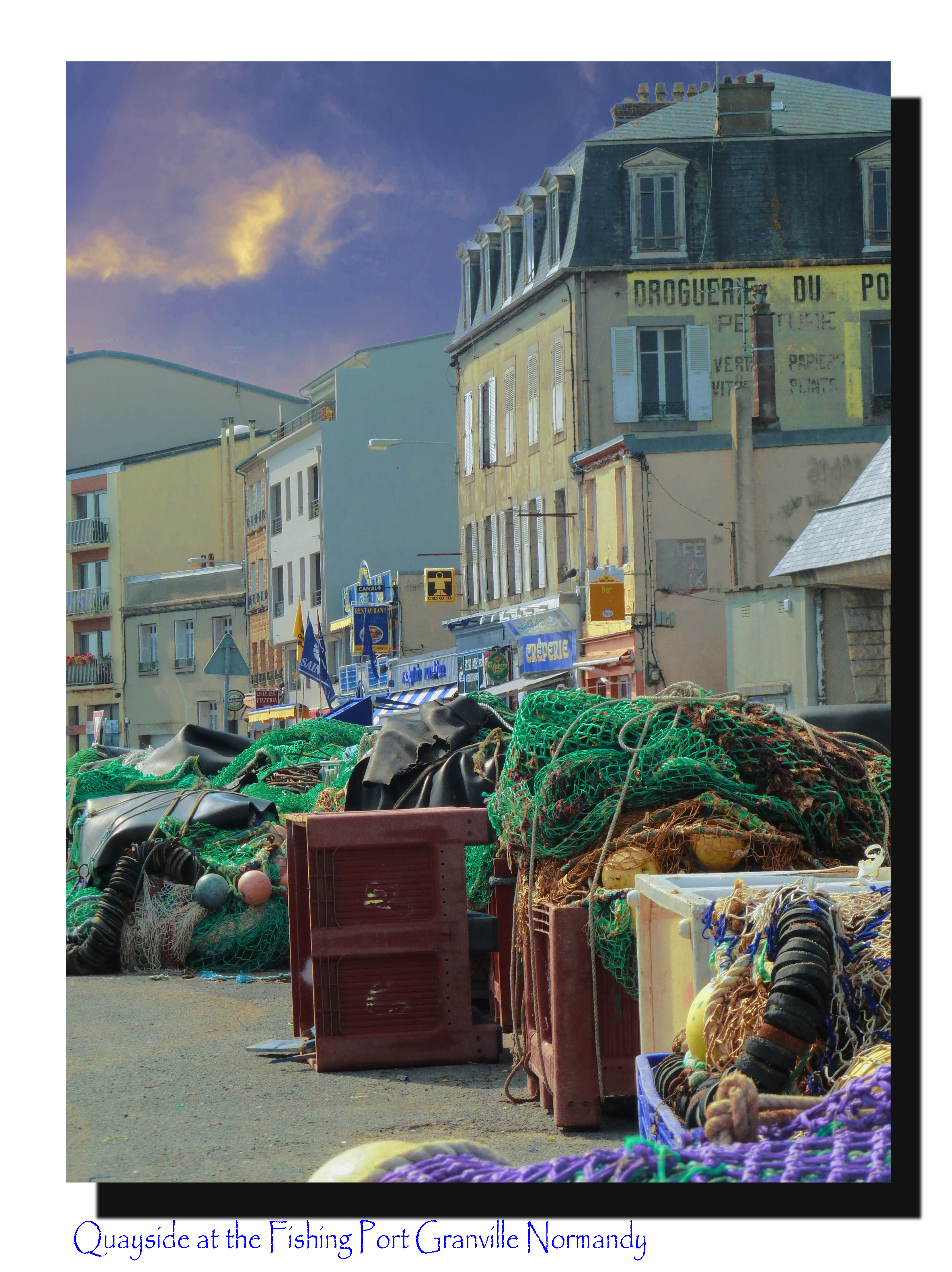 fishing nets on quay of port with old buildings and stormy sky