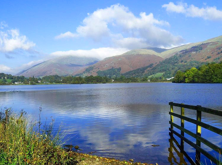 Sky reflecting in tranquil lake with mountains and blue sky with clouds