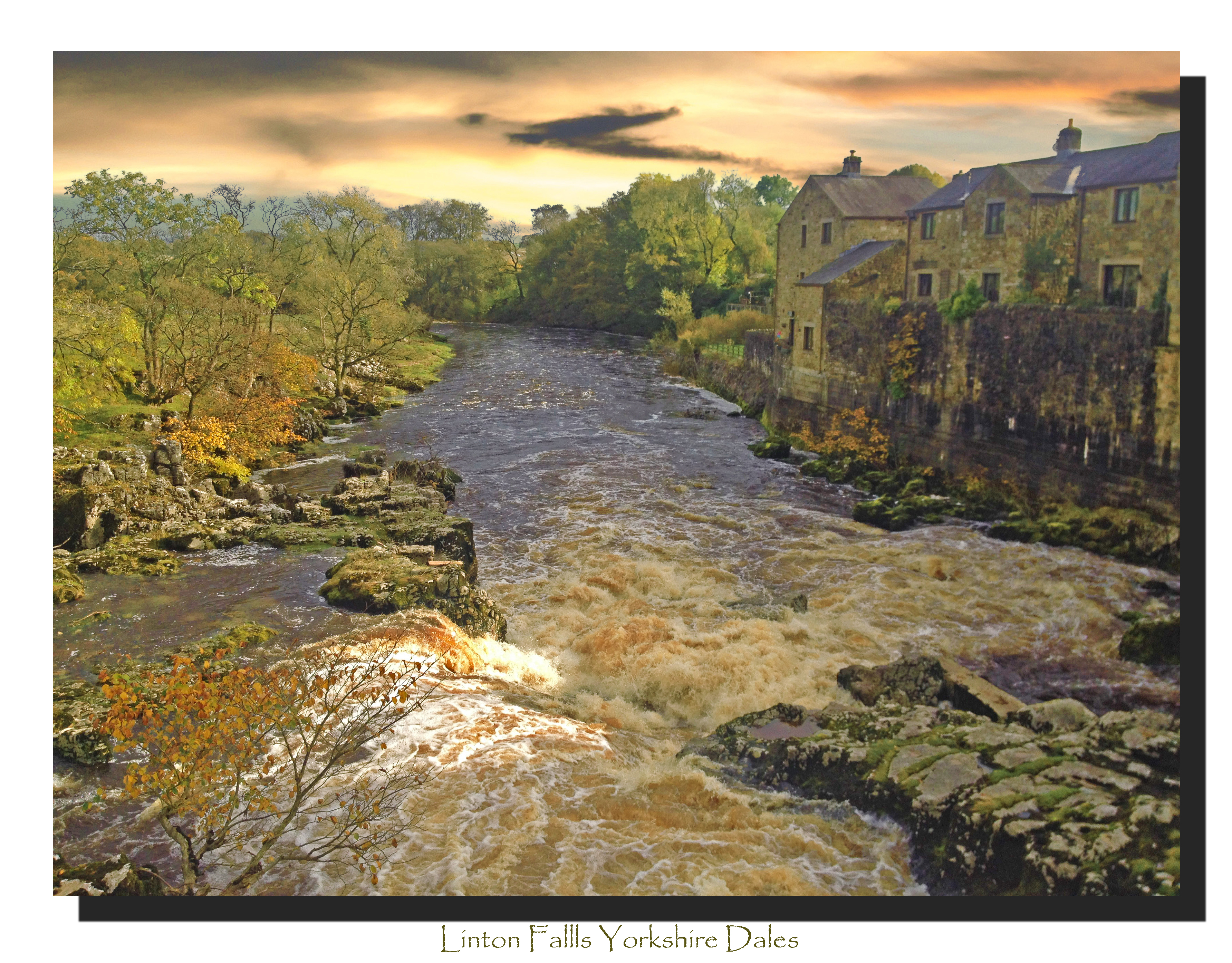river waterfall with houses next to river and trees with stormy sky