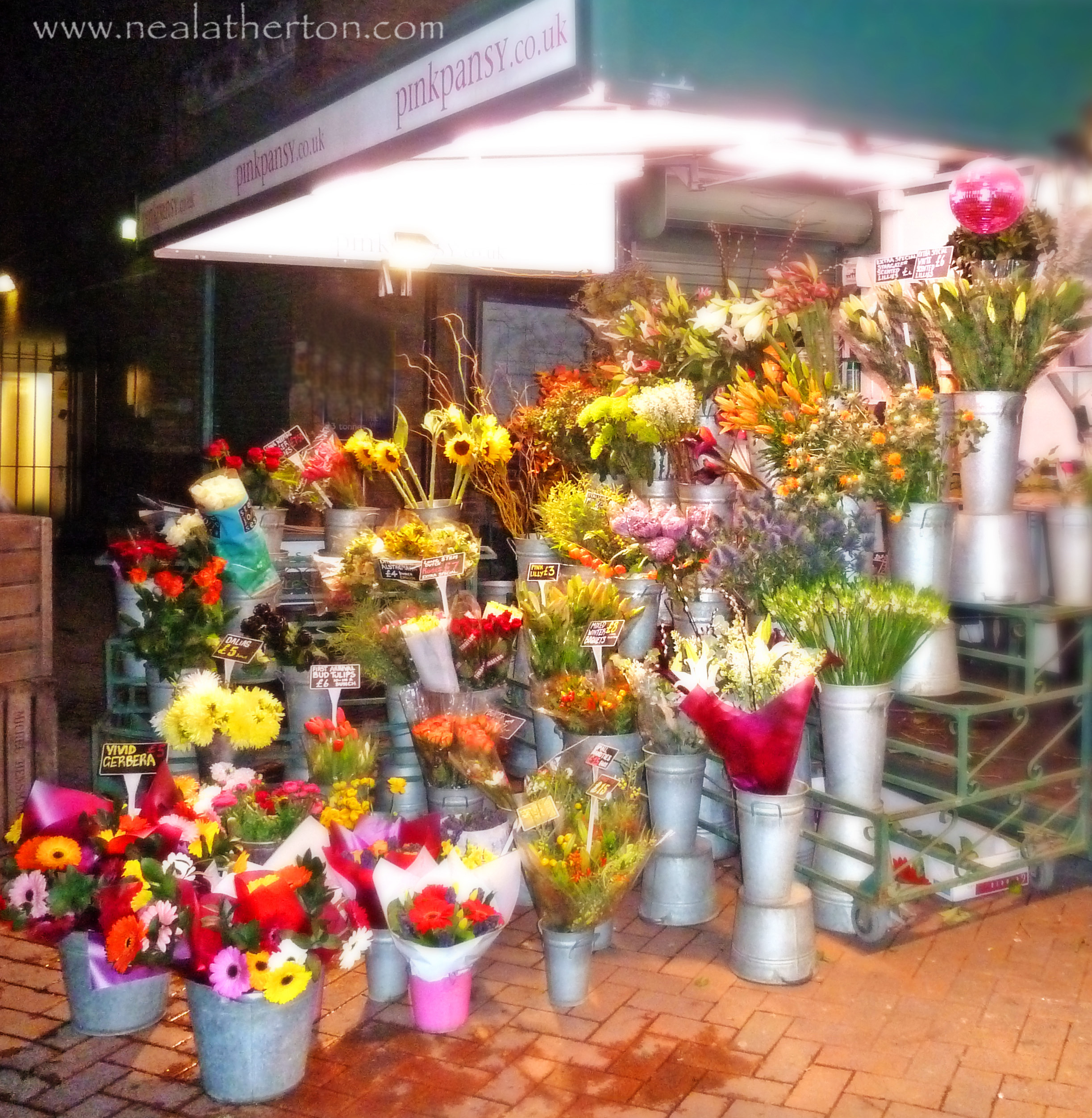 metal buckets of flowers in all colours on flower seller stall