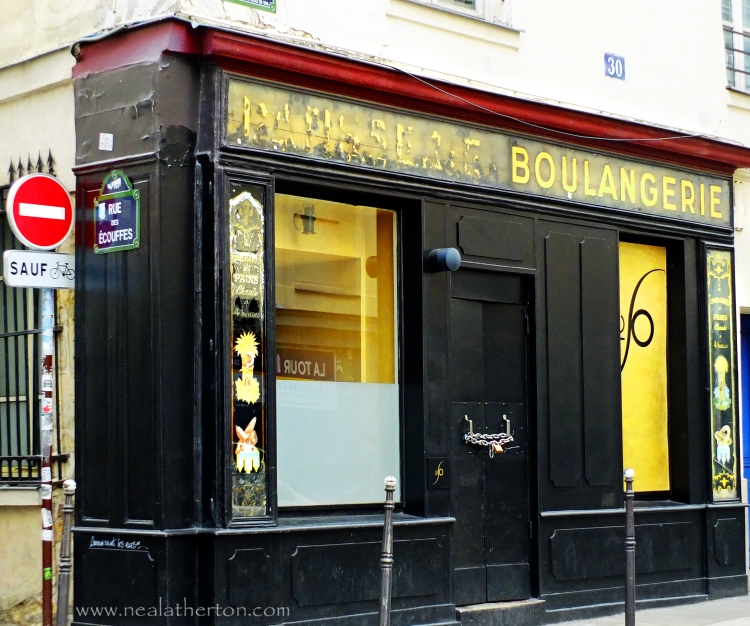 old closed shop boulangerie with black front and gold lettering in paris