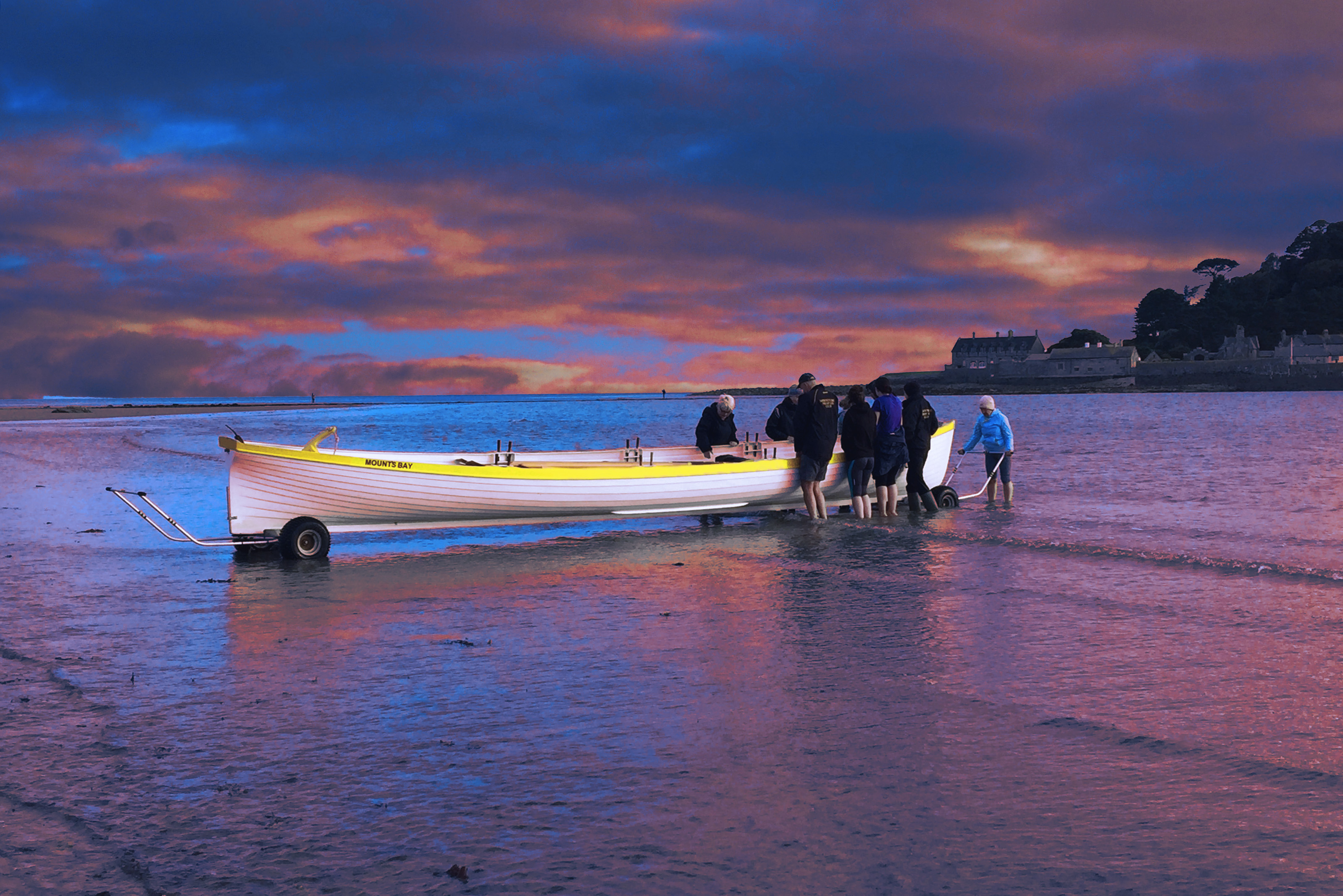 gig boat with people launching it into bay in evening light
