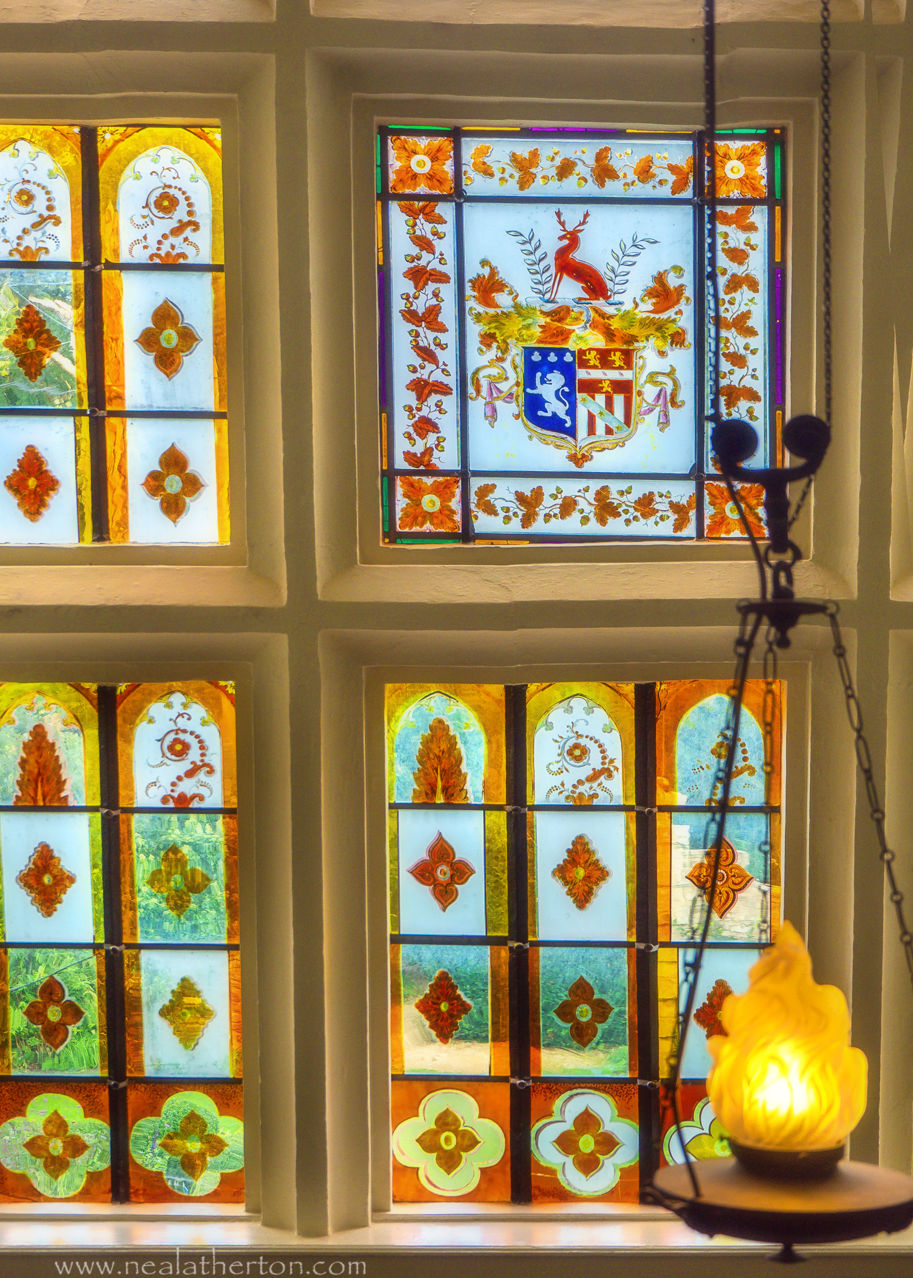 stained glass with symbols and coat of arms in stone frame