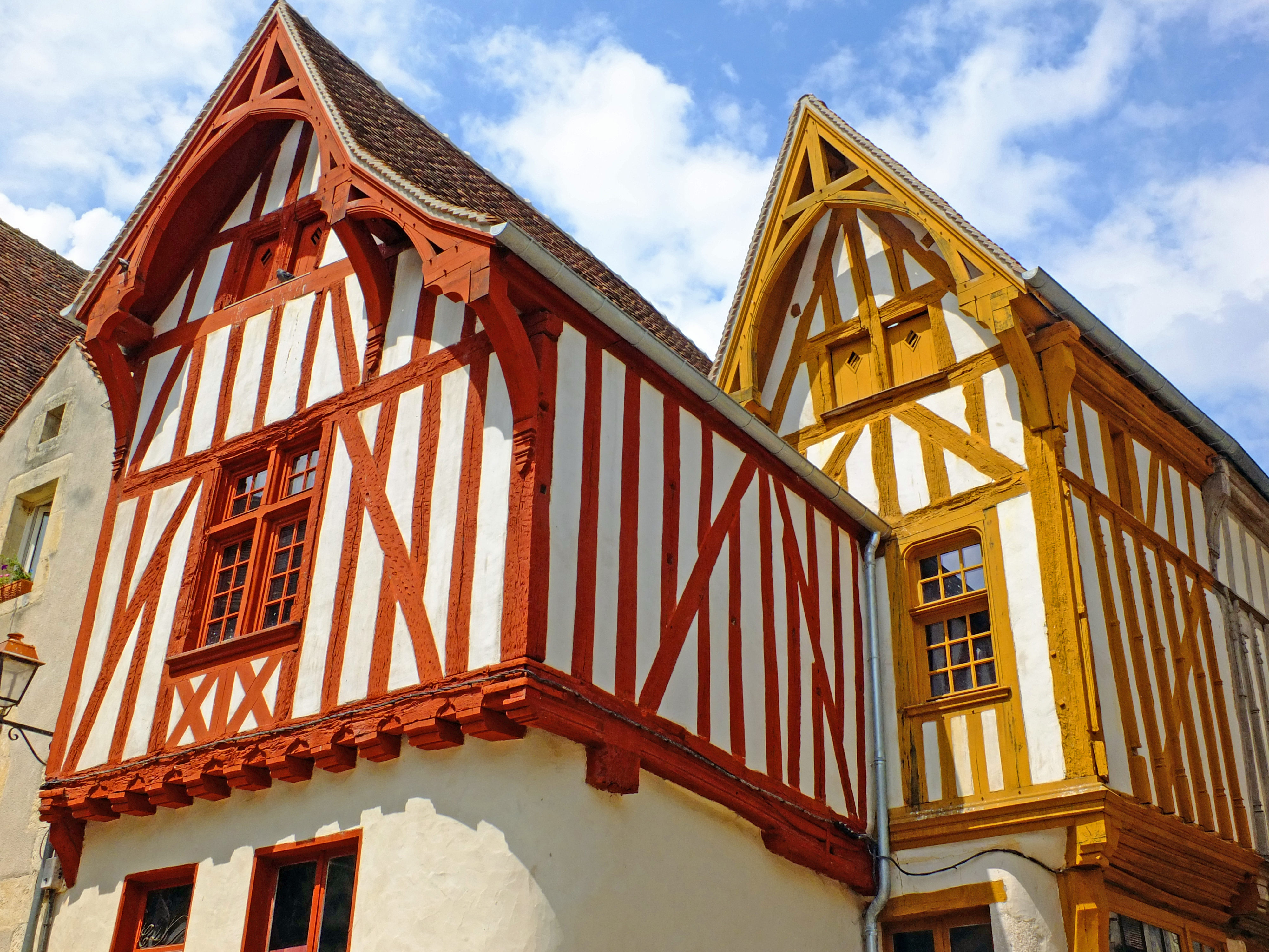 half timbered houses in french village with pointed roofs and blue sky