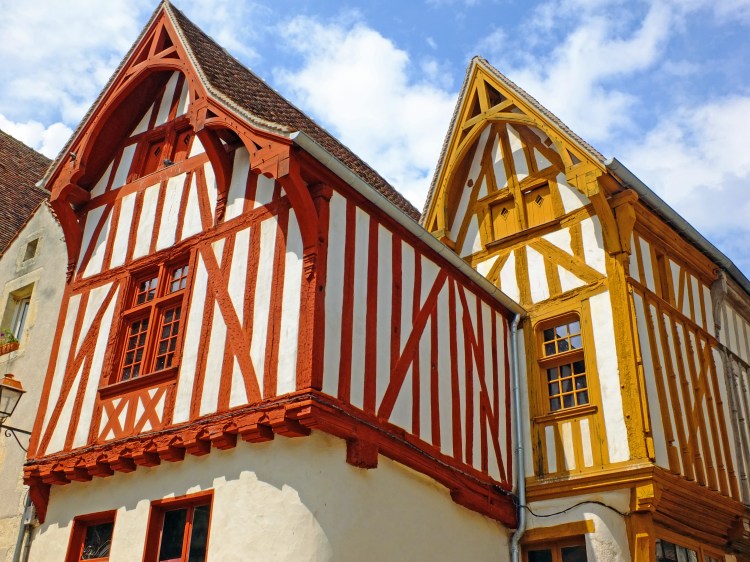 half timbered houses in french village with pointed roofs and blue sky