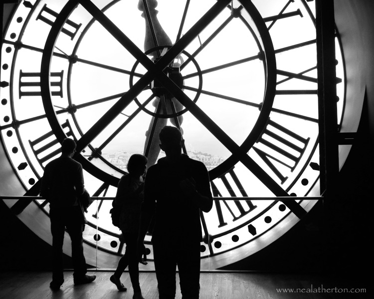 people behind a huge clockface looking through to city