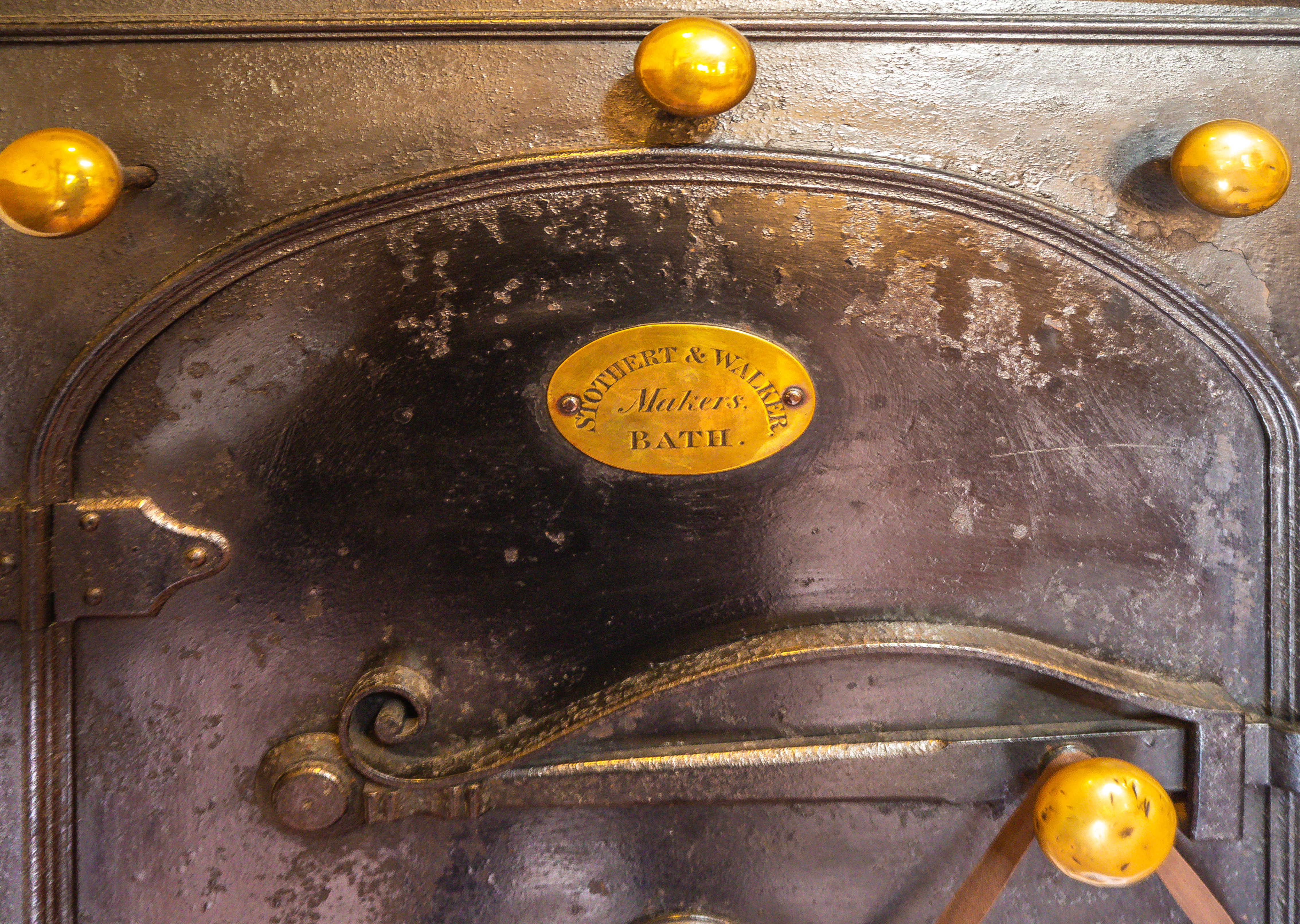 cast iron oven door with brass fittings and name of maker