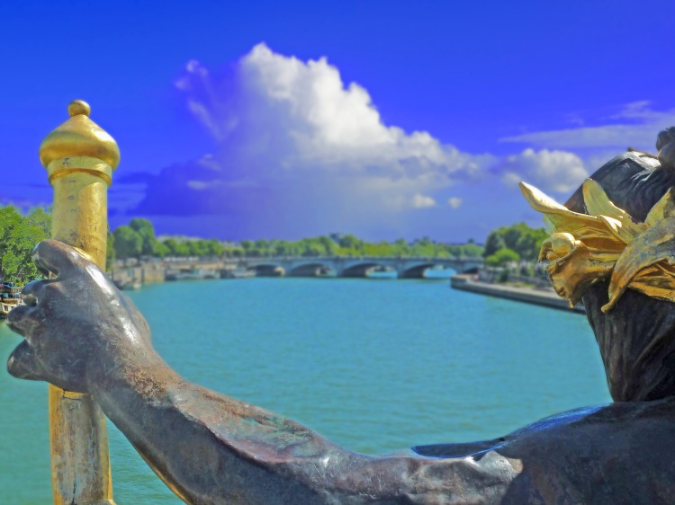 Bronnze statue of man with gold on bridge over river