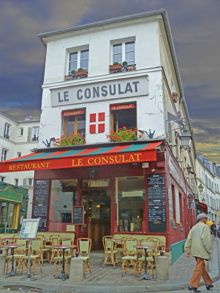 tall white restaurant with red awning and terrace with tables with man walking