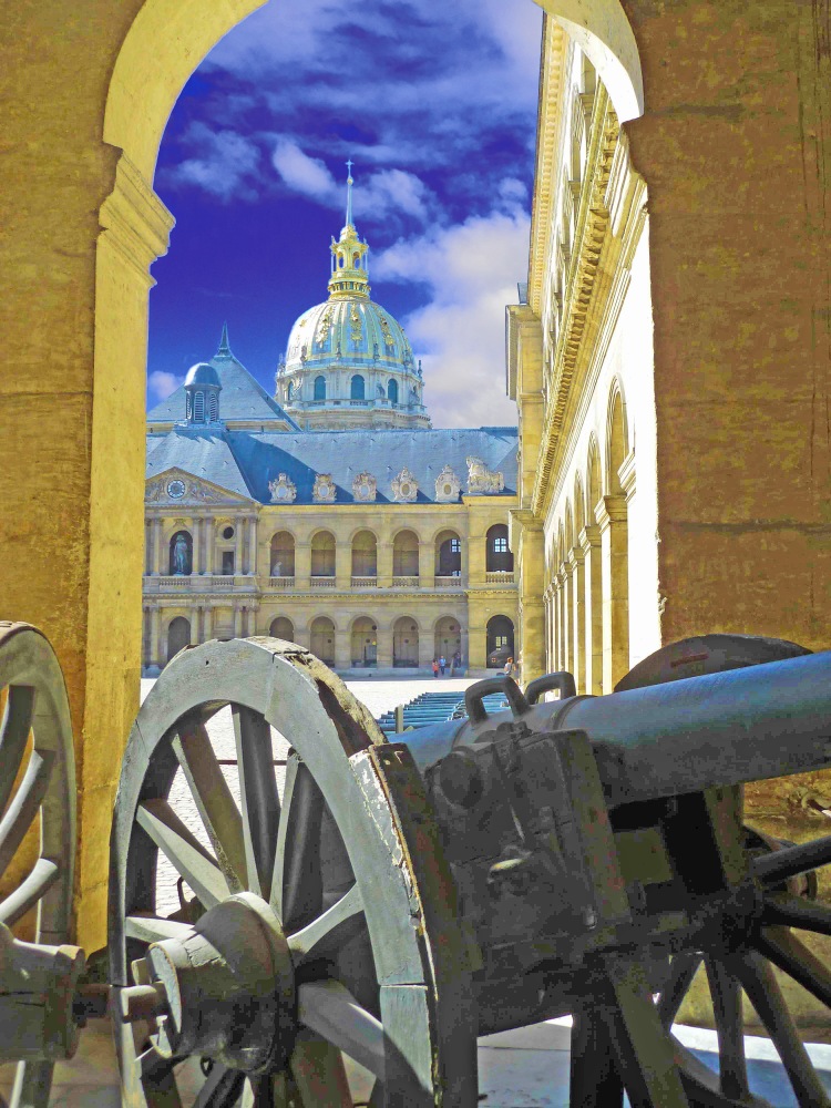 cannon in courtyard with arch and old historical building with golden dome and blue sky
