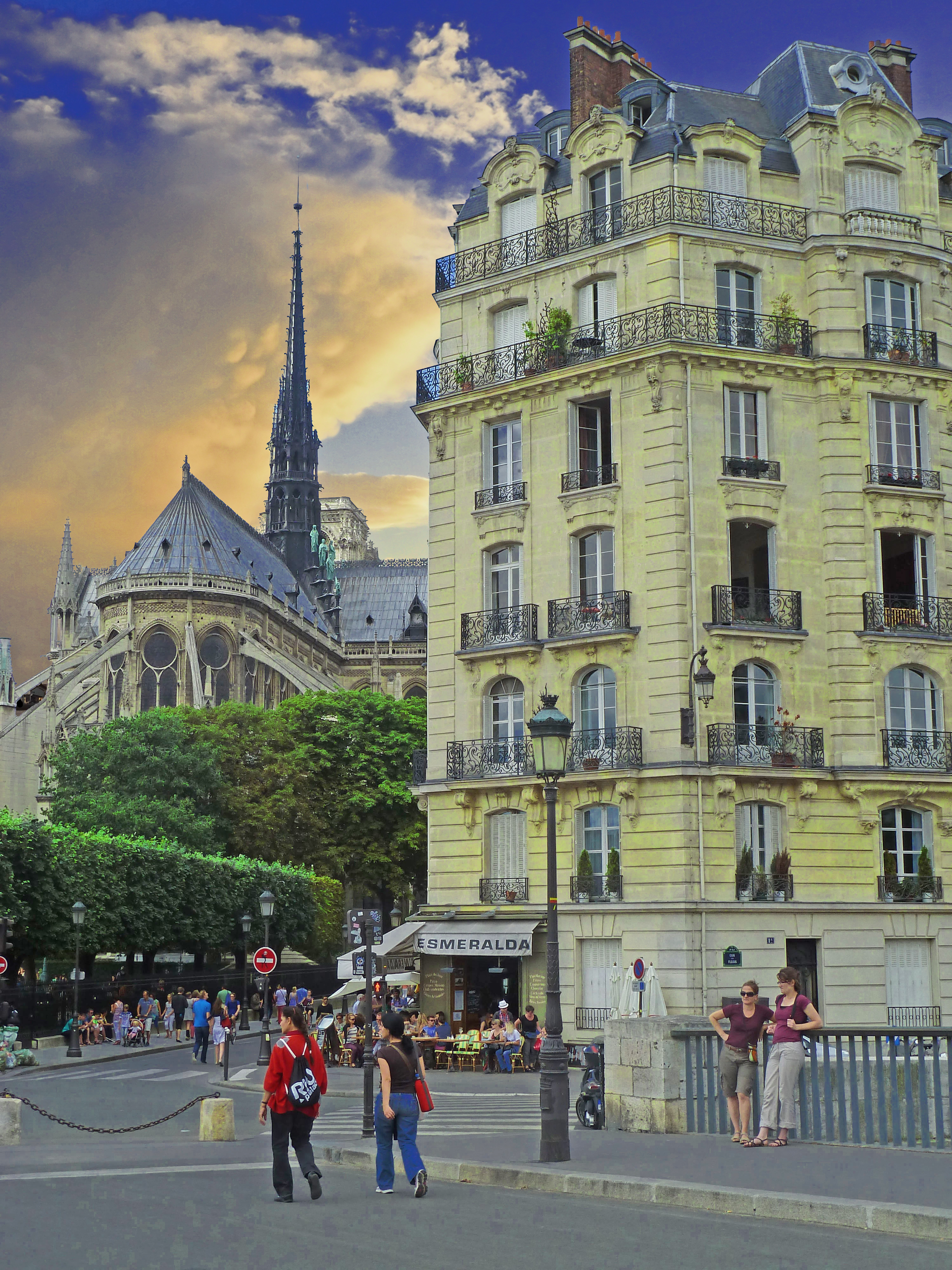 people walking from bridge with building with balconies near a cathedral