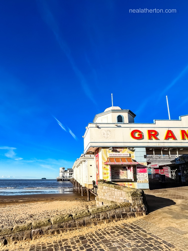 Red lettering of Weston GRand Pier stands out against a vivid blue wintery sky
