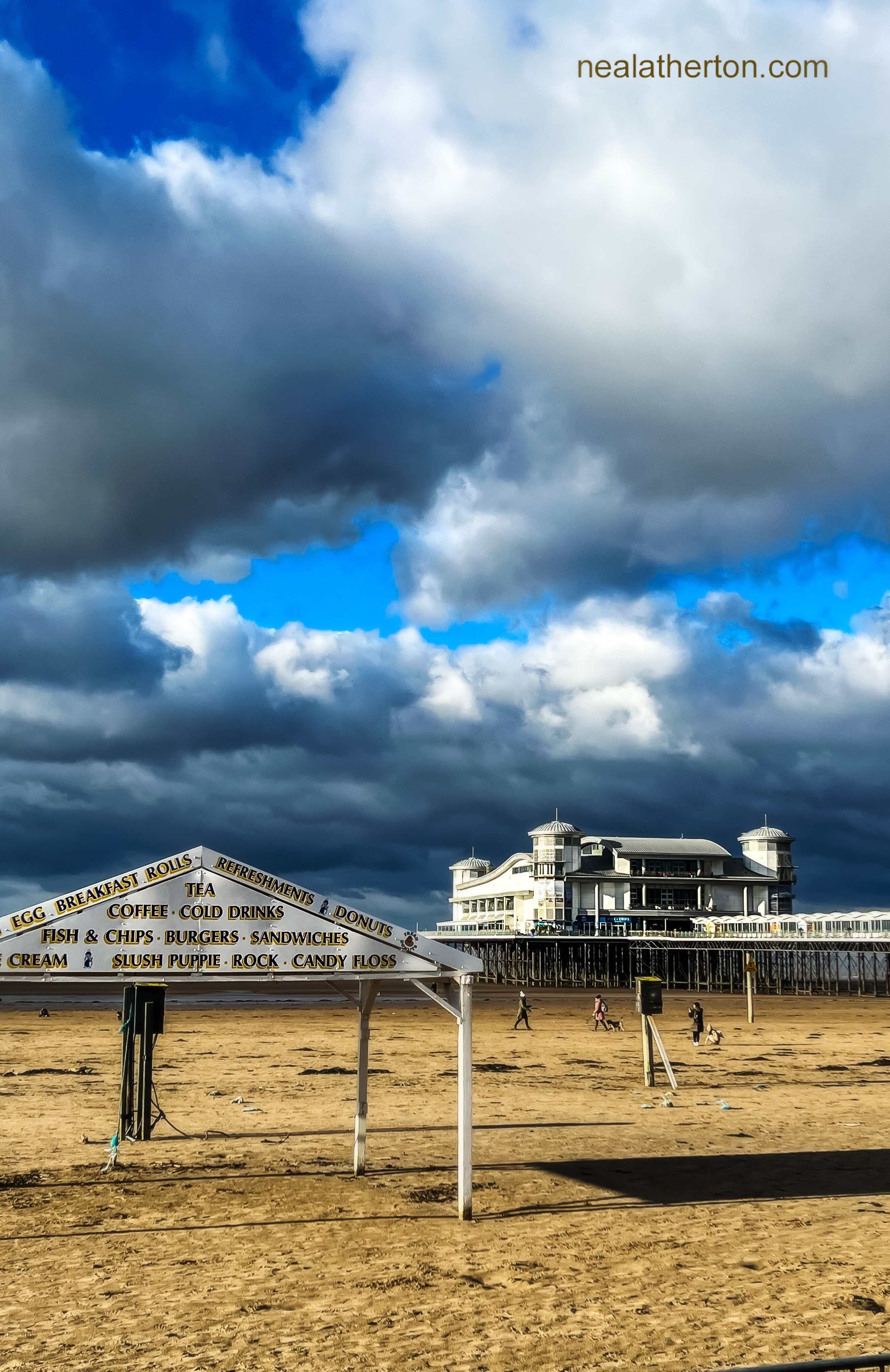 Food shelter on the beach in Somerset infront of Weston Super Mare grand pier with heavy wintery clouds above