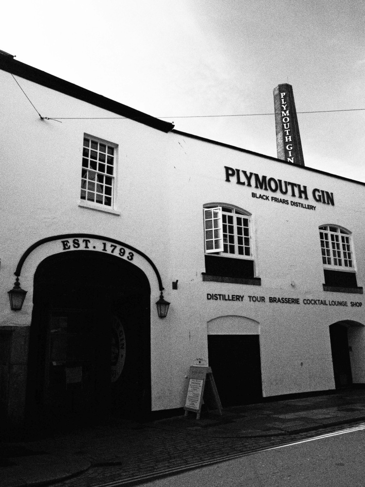 distillery in plymouth of gin with large door and signage with chimney