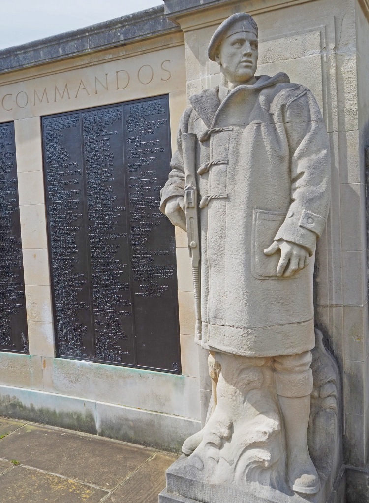 stone statue of naval soldier with memorial with names on plaques
