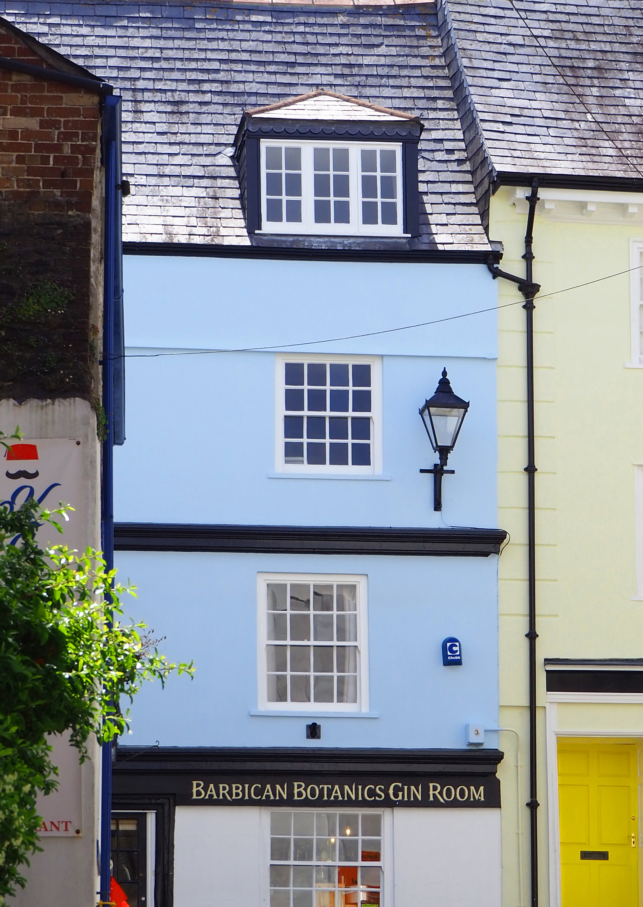 Old blue painted building with tiled roof and lamp