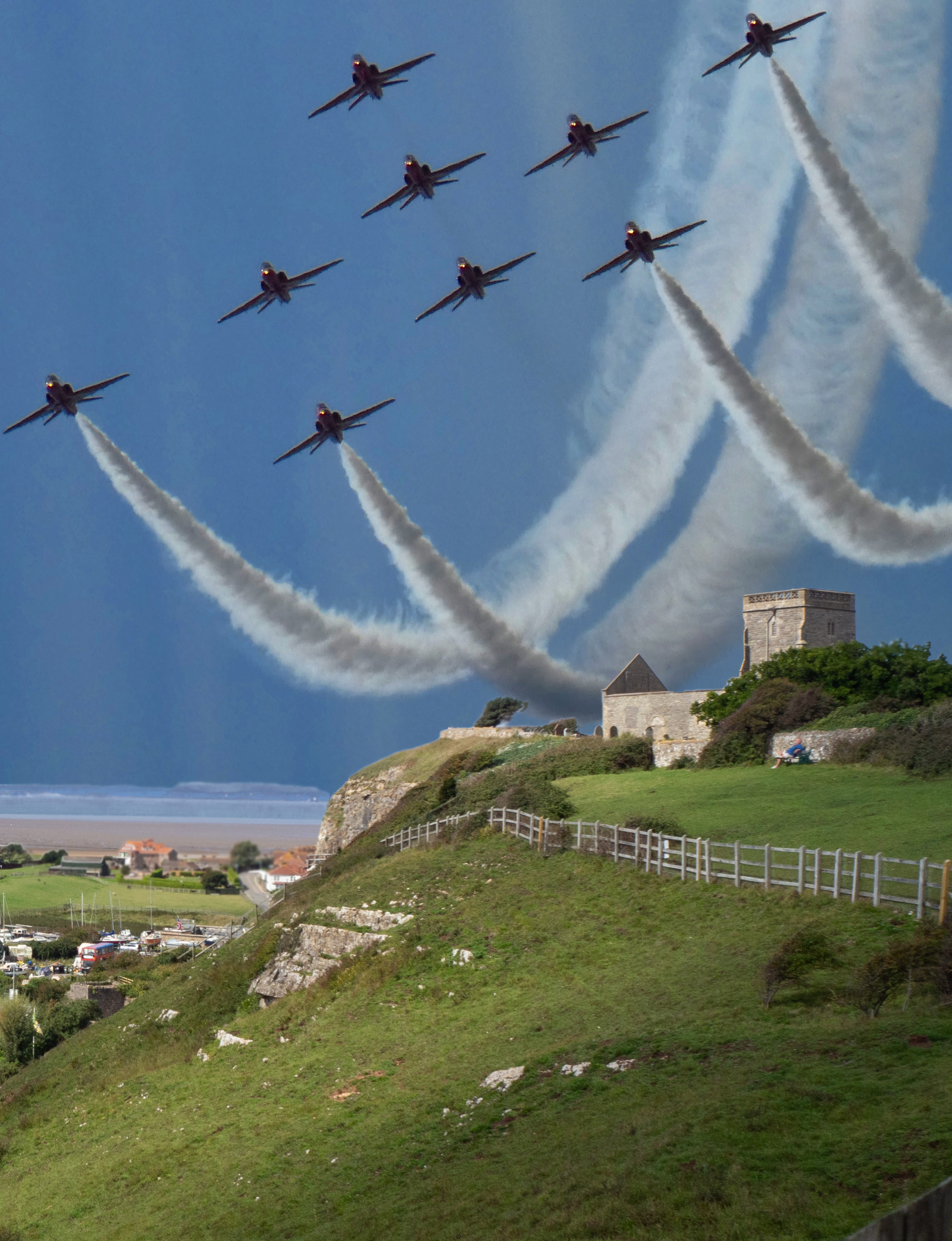 red arriows planes with jetstream over church on hill with sea and dark sky