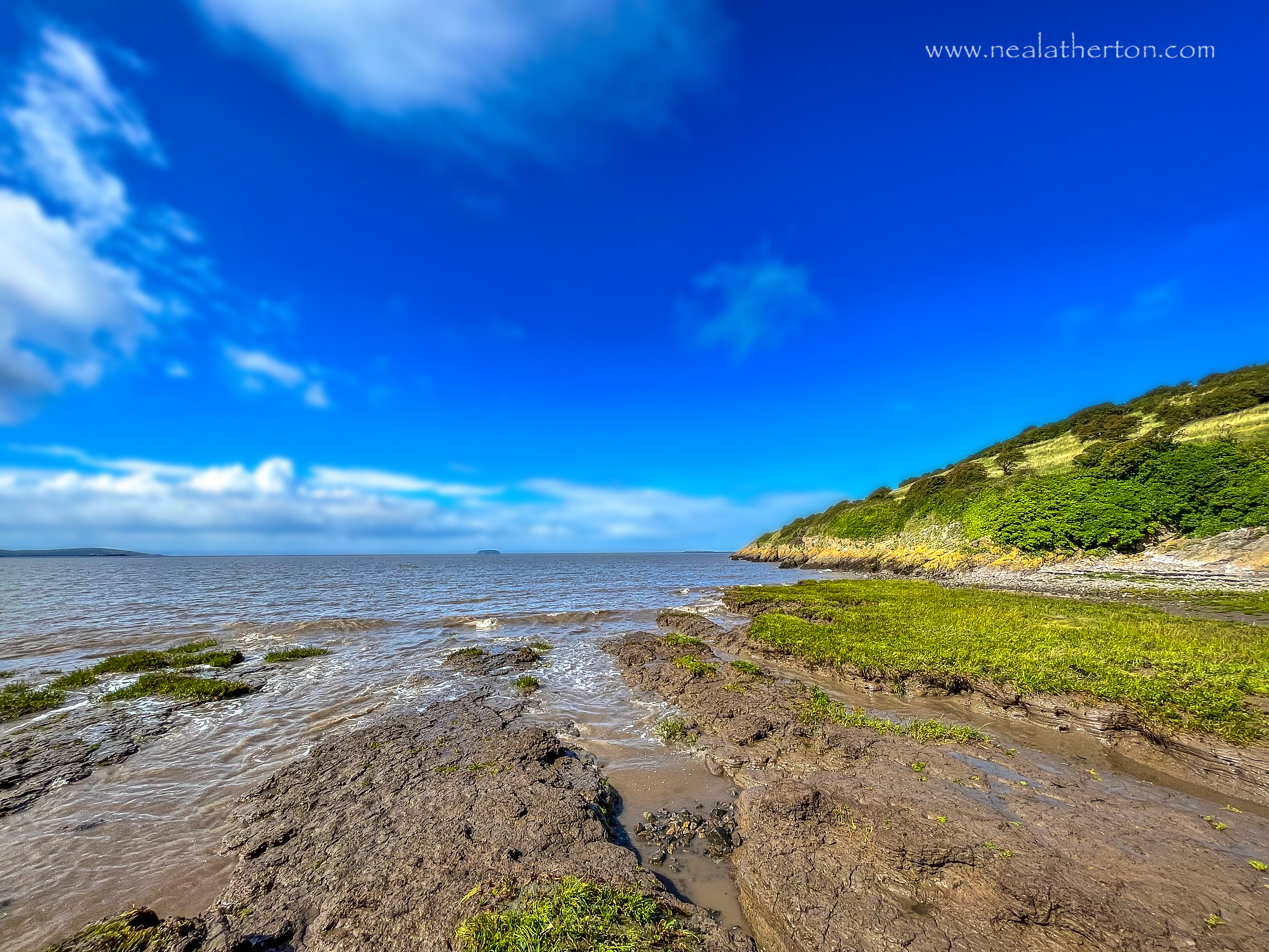 sea and shore near sand point somerset with blue hazy sky