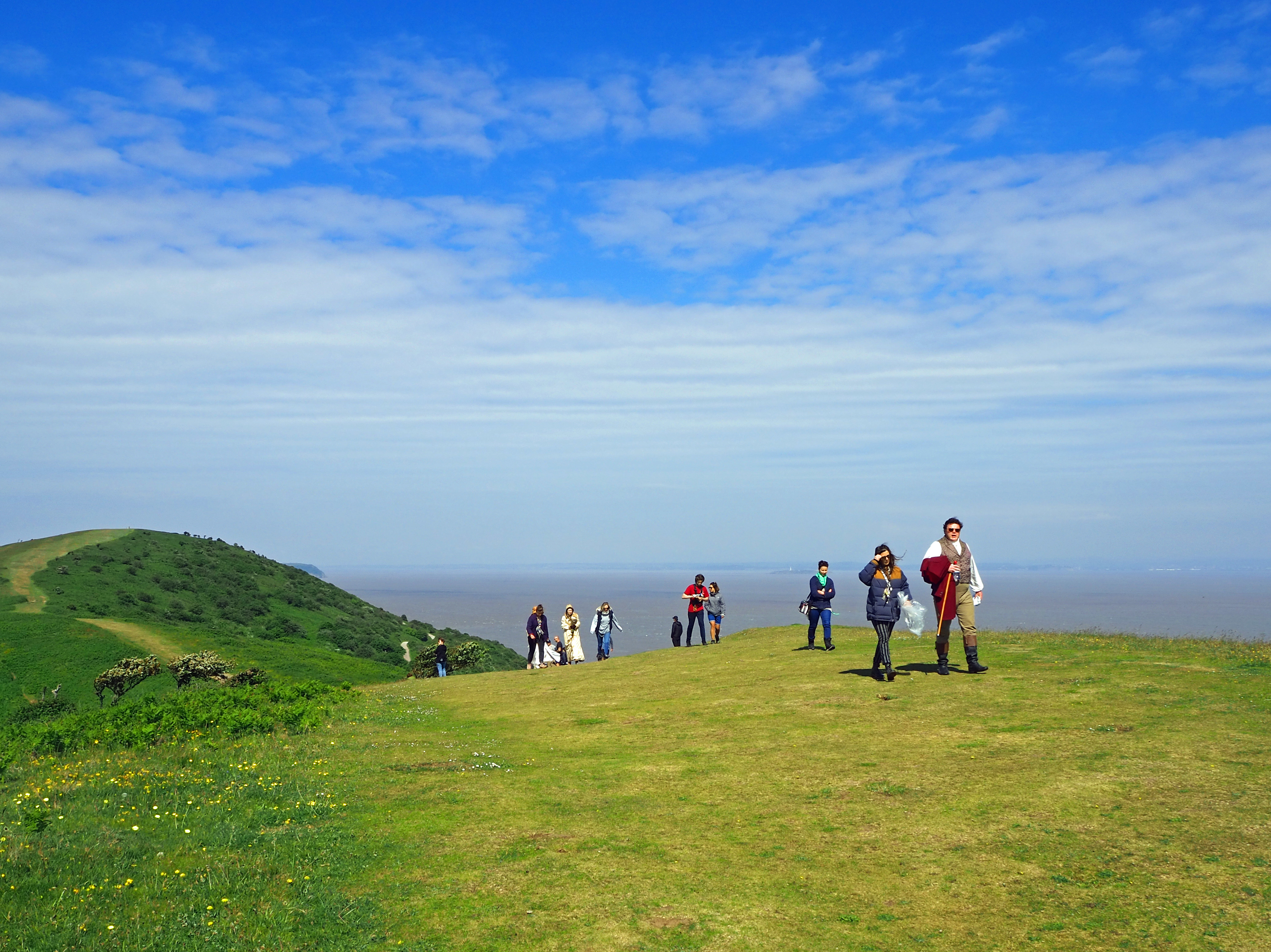 actors walking on hillside on island in costume for tv filming Sanditon