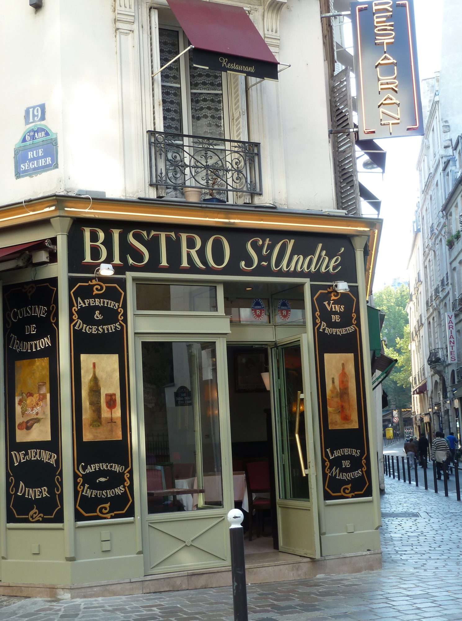 bistro front with glass painted signs on cobbled street