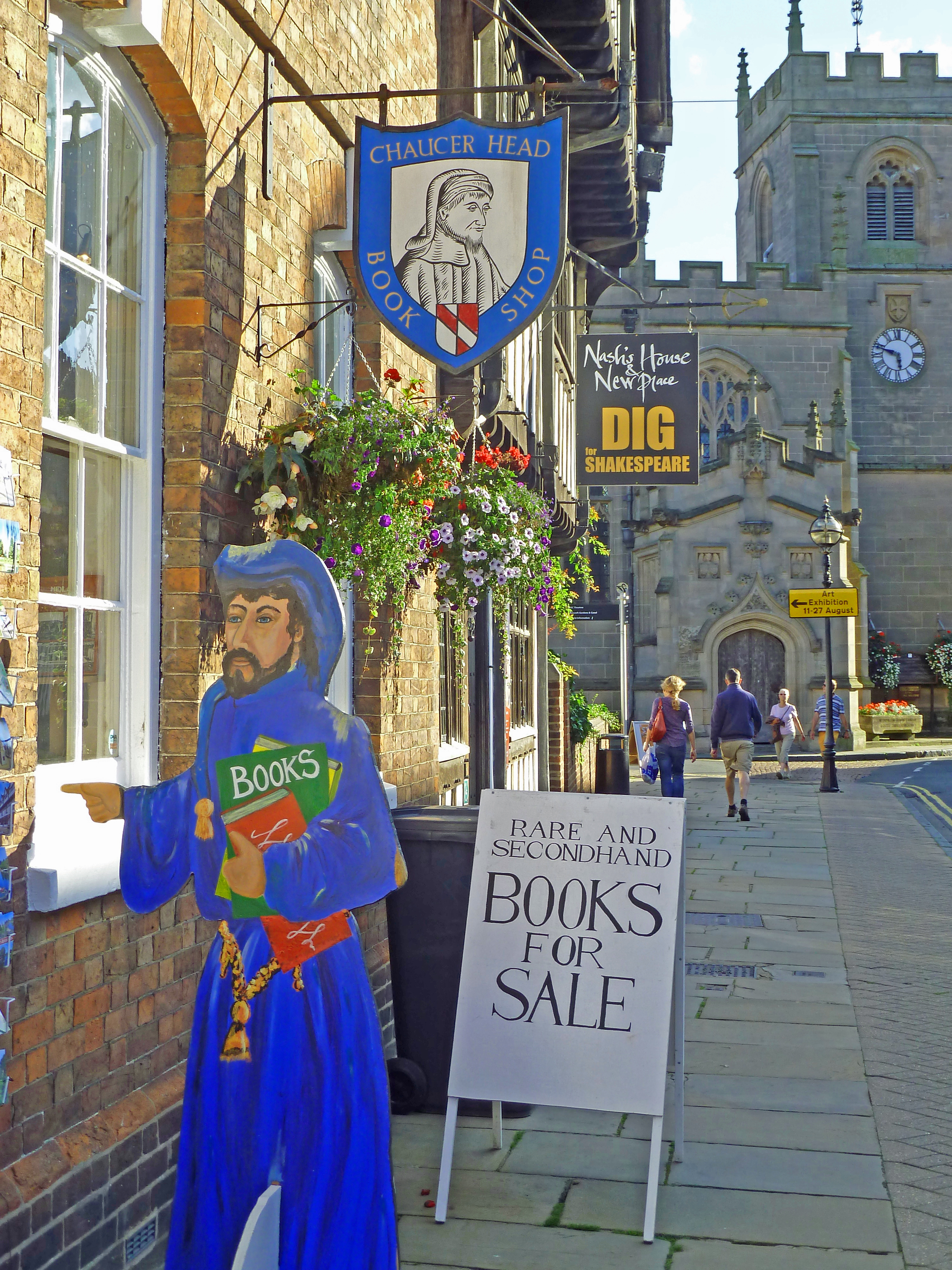 cut out figure of man advertising bookshop with church and people