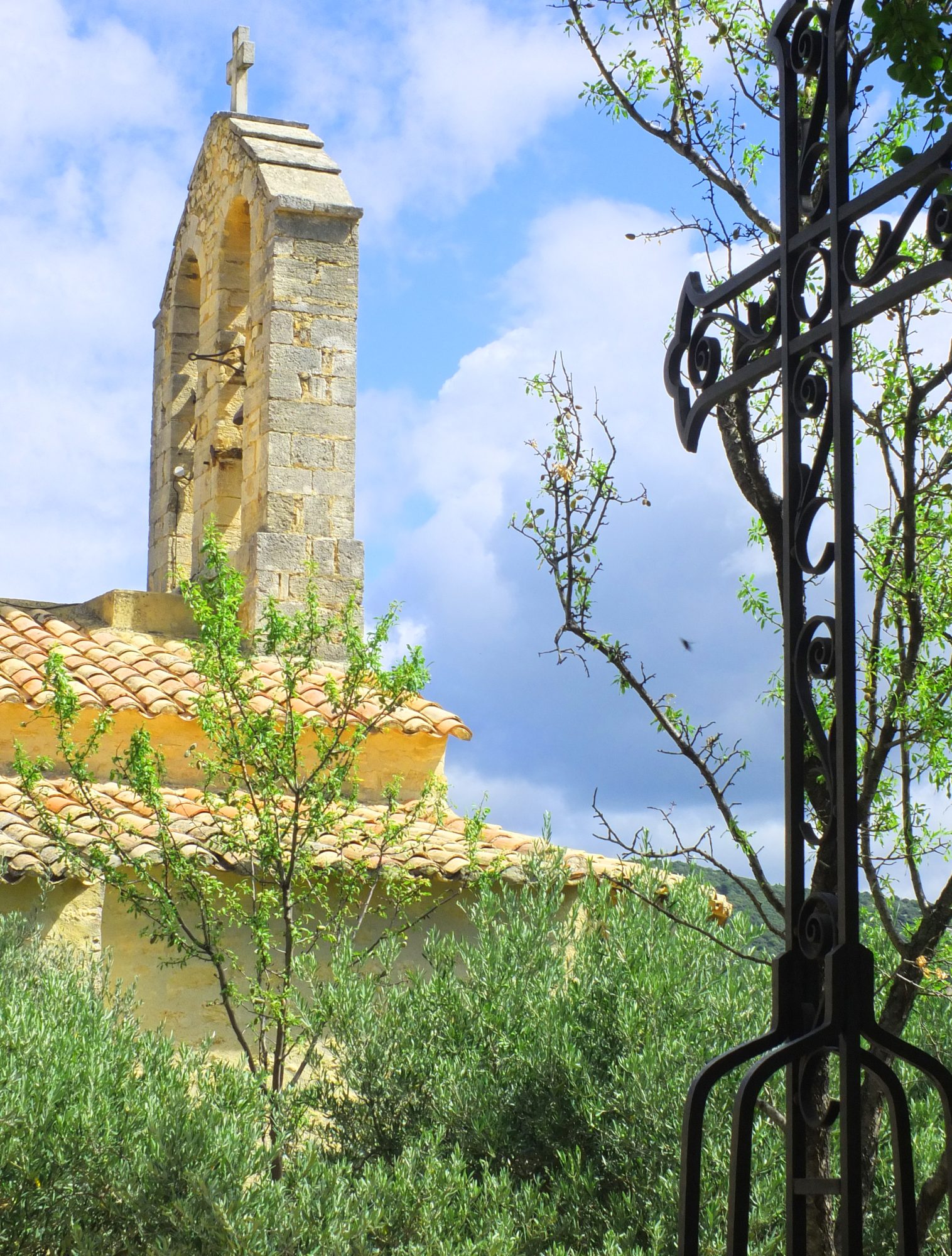 church bell tower with tiled roof and metal cross