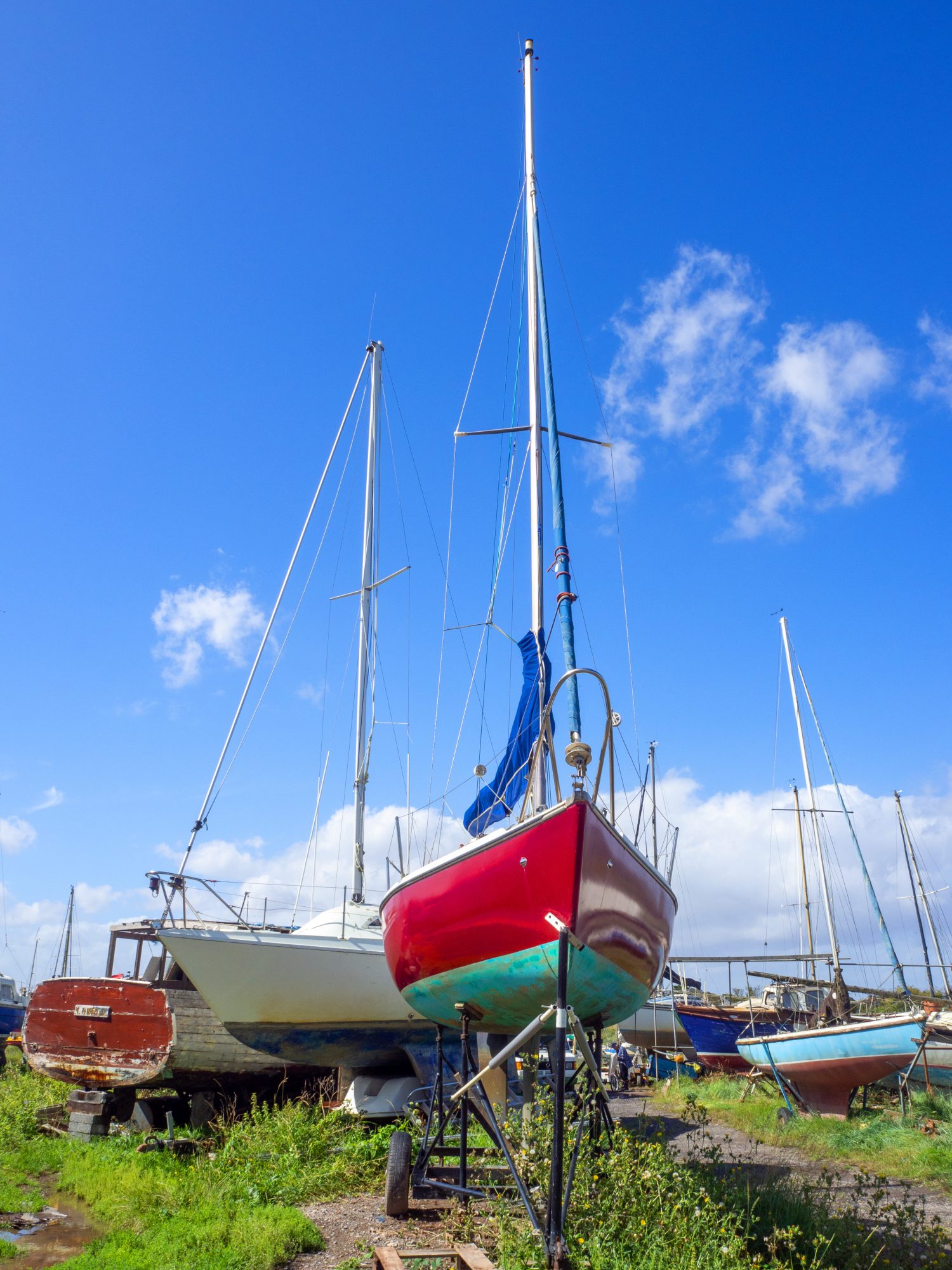yacht in dry dock with other boats and blue sky