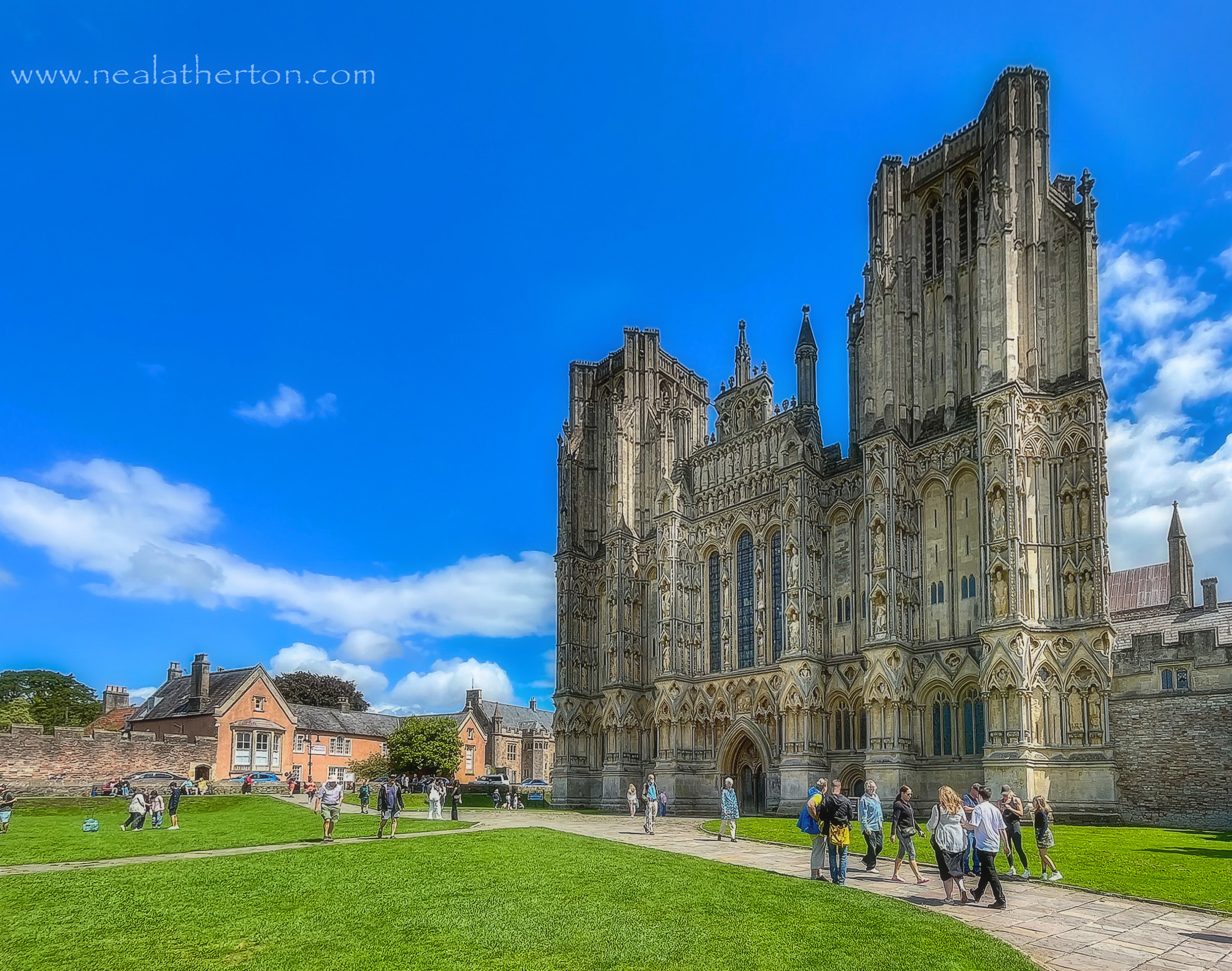 grass lawn in front of cathedral frontage with other buildings and people