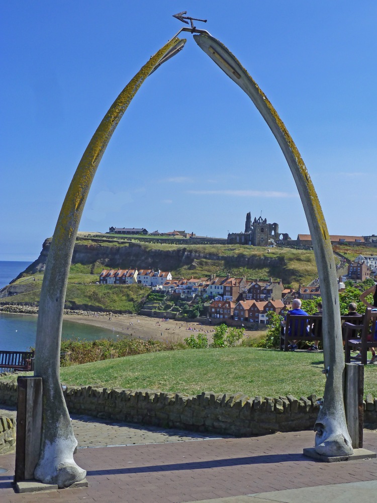 whalebone arch with headland and abbey and beach and sea