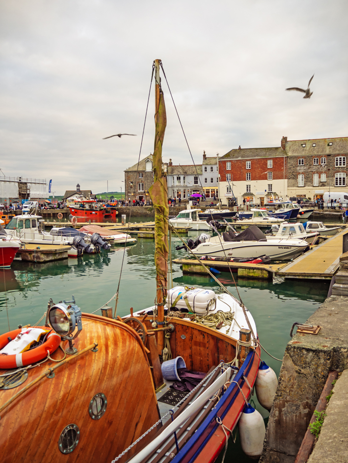 Wooden yacht in a harbour with other boats and seagulls