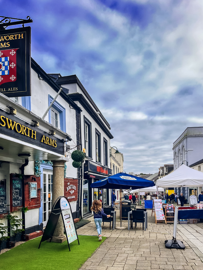 Market stalls along a town street in front of a pub